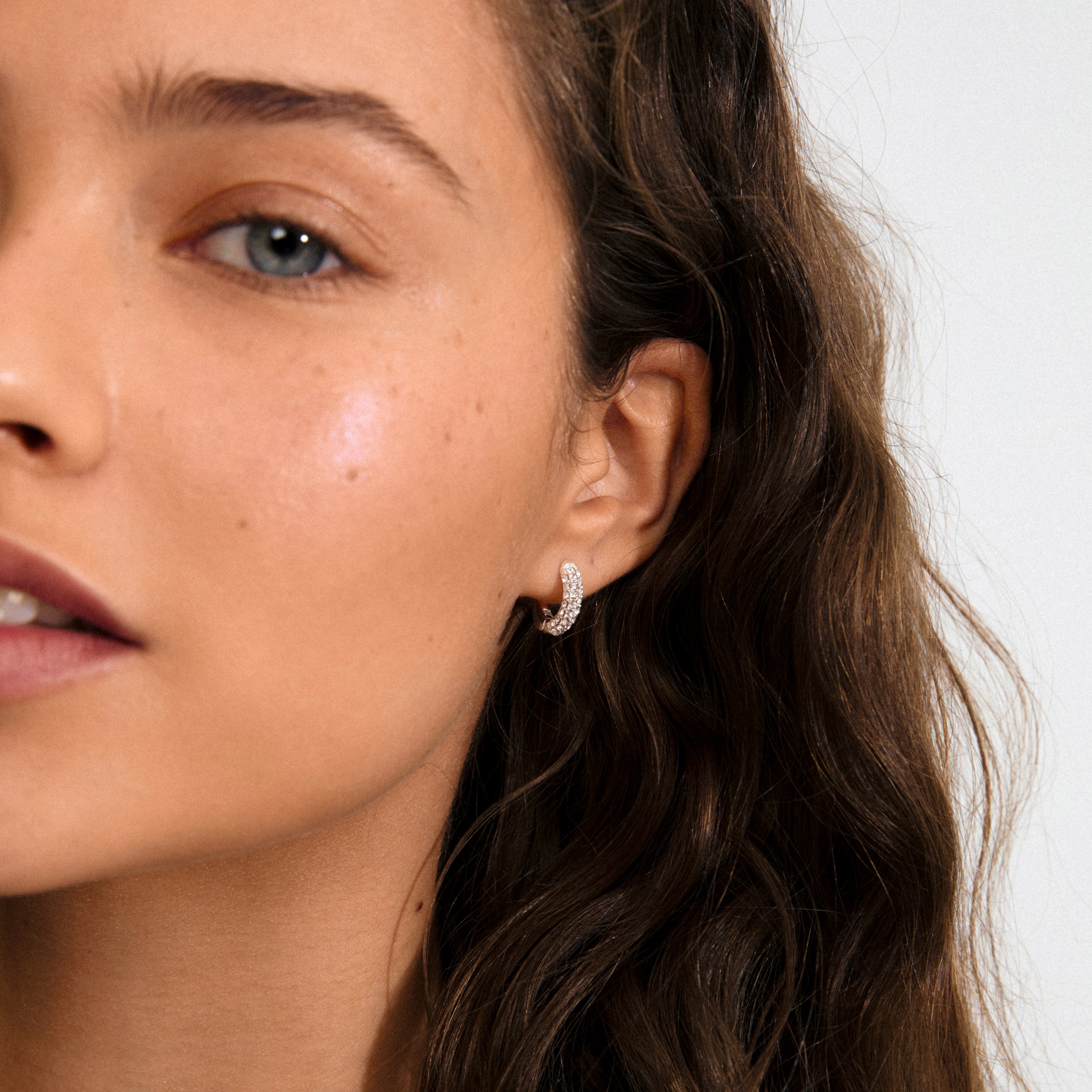 TATUM small hoops silver-plated, featuring sparkling Preciosa crystals, perfect for versatile day-to-night wear. Crafted from 96% recycled materials with easy click clasps for comfort.