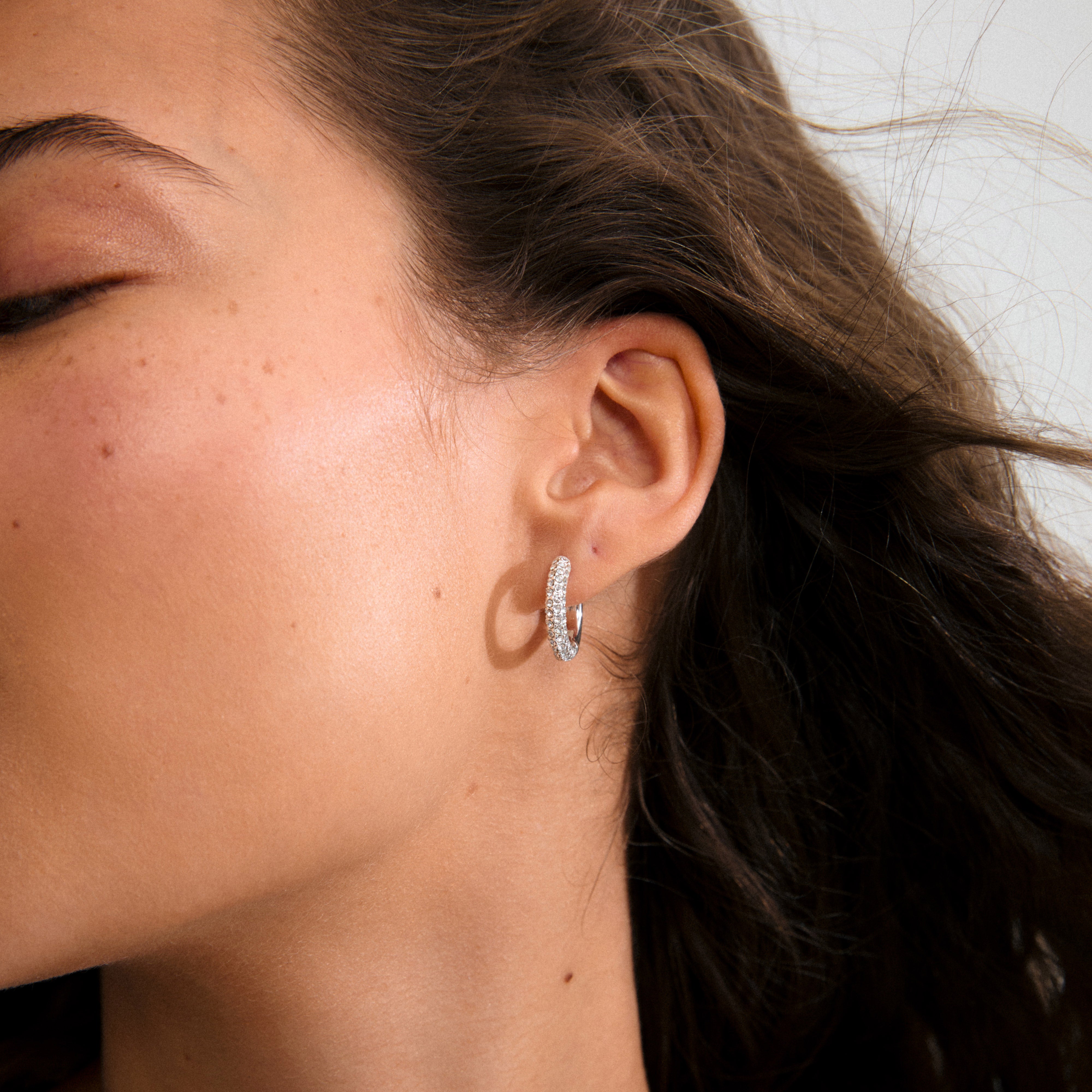 TATUM medium hoops, silver-plated, embellished with sparkling Preciosa crystals, featuring click clasps for comfort. Perfect for both casual and evening wear. Fashioned from 97% recycled material.