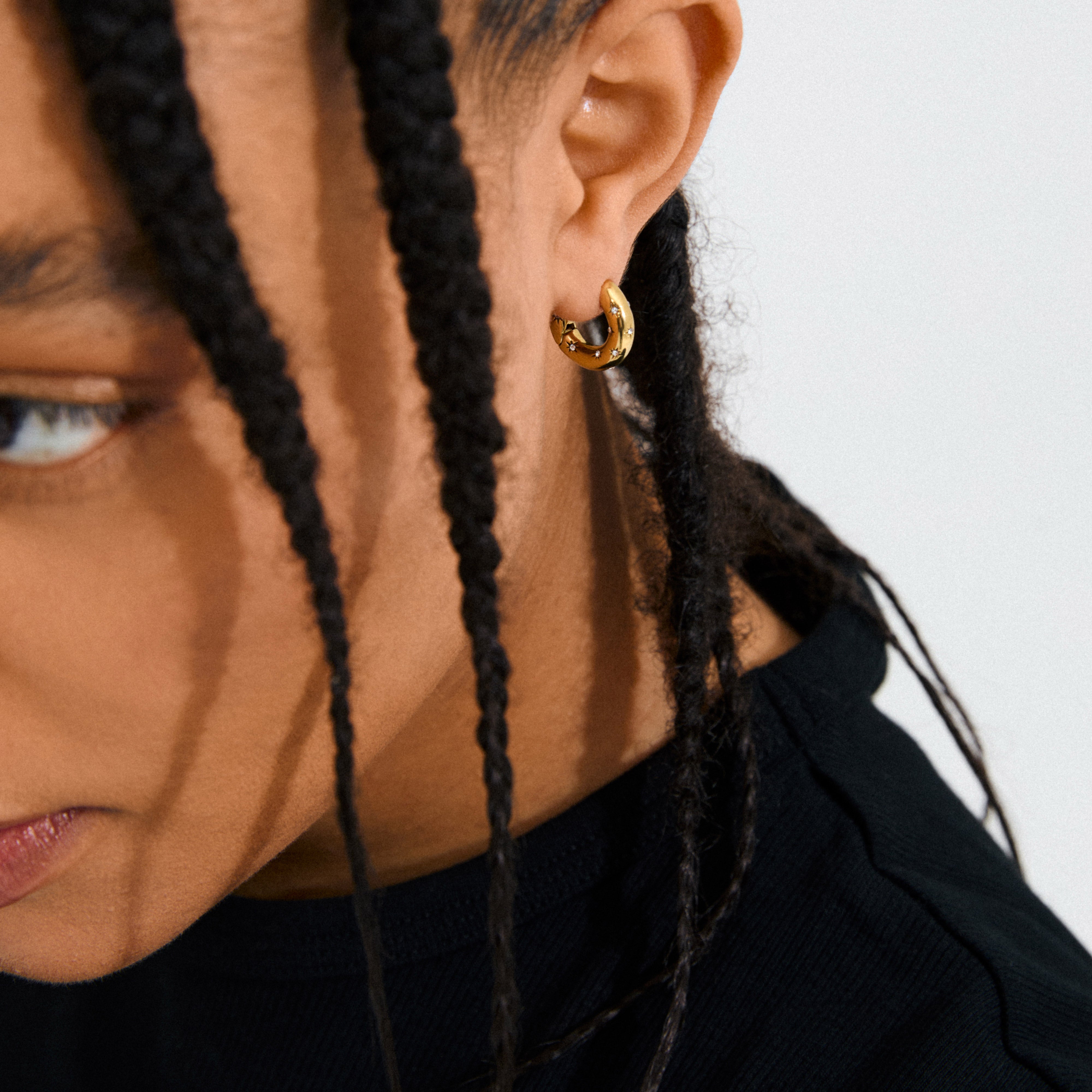 Gold-plated NEVAEH hoops with click clasp and petite Preciosa crystals, designed for a sparkling, versatile look using 97% recycled materials.