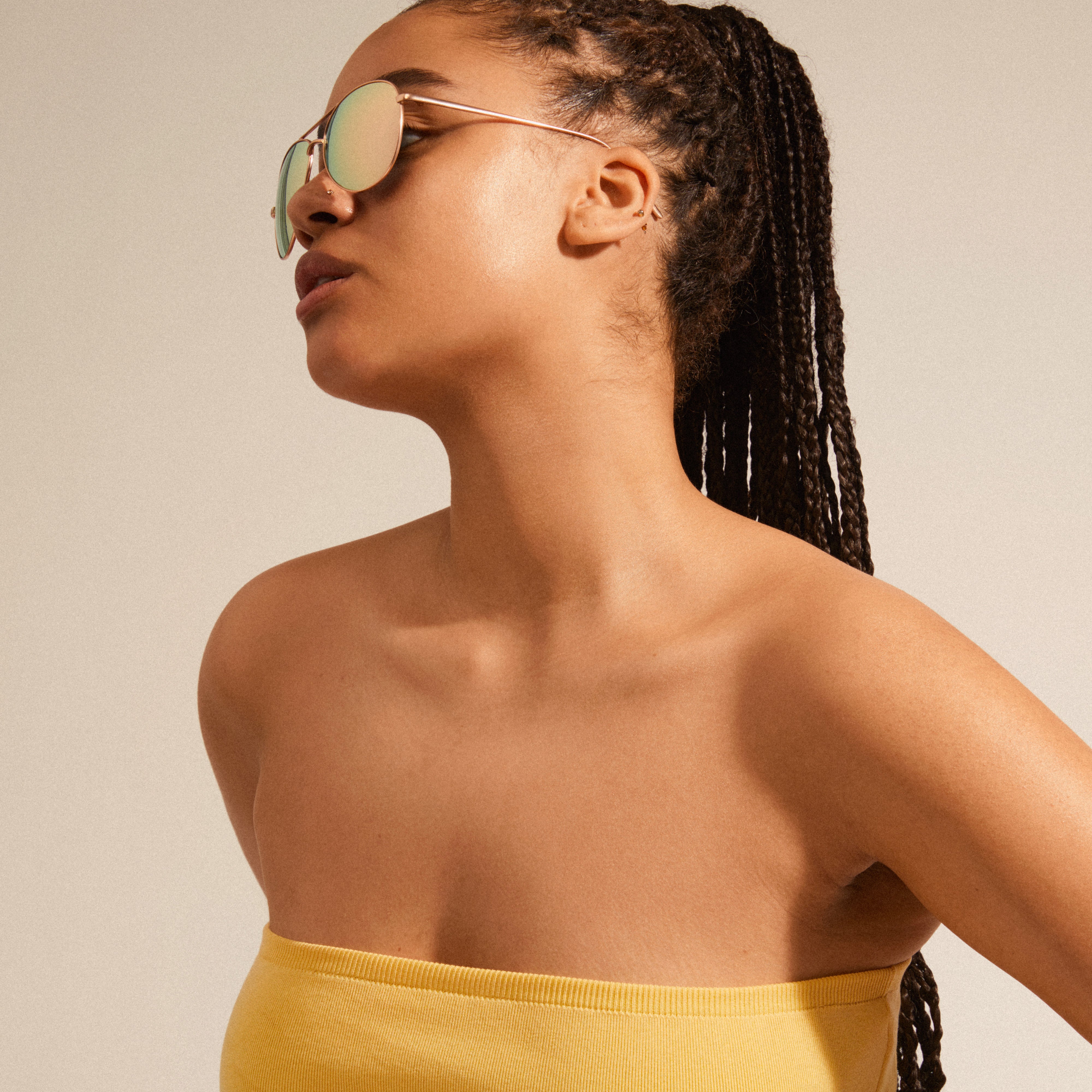 NANI pilot sunglasses with pink lenses and a rose gold frame, worn by a woman, showcasing their stylish and unique design.