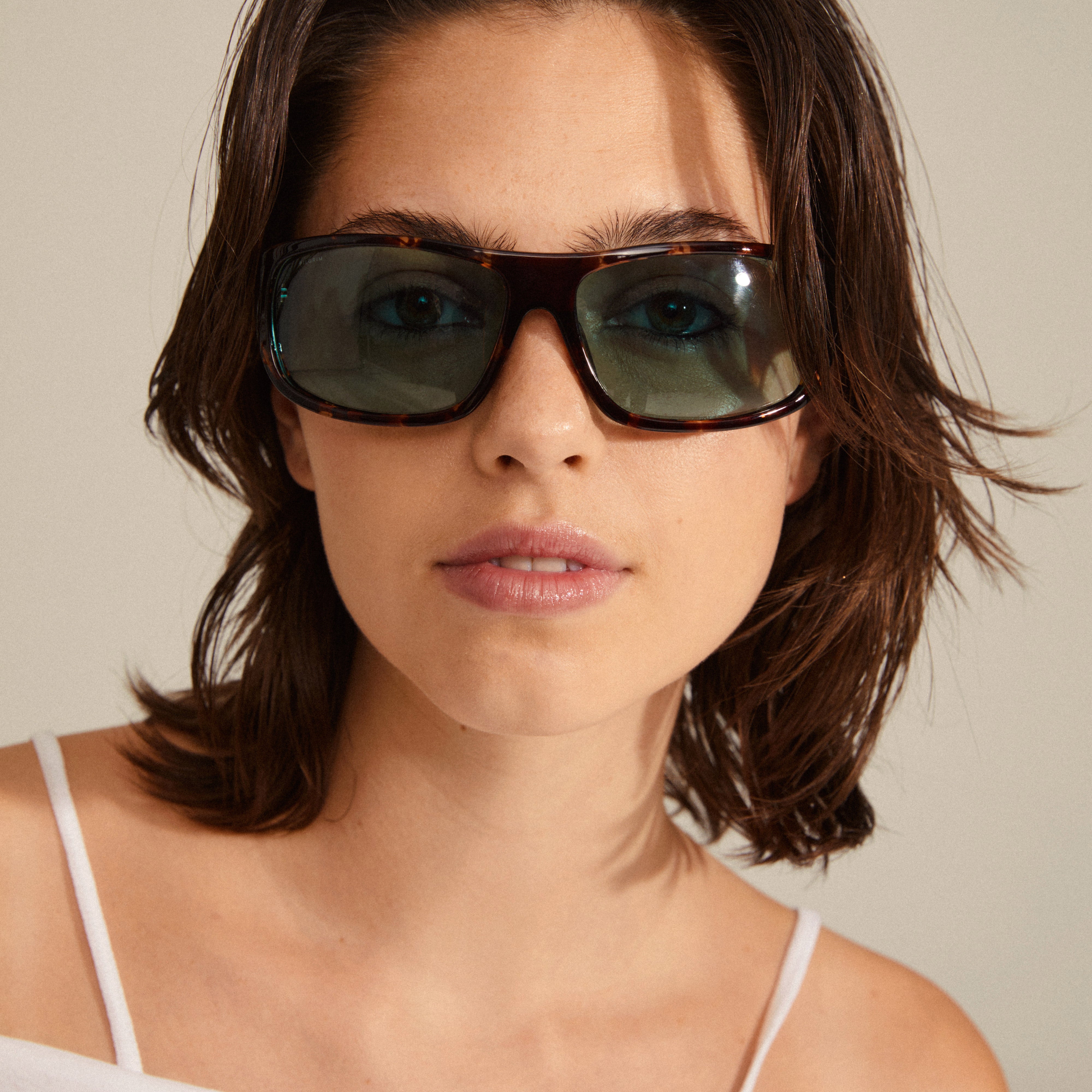 Gertrud sunglasses tortoise brown on a woman's face, showcasing trendy light blue lenses and classic design, embodying Pilgrim's blend of timeless style and edge.