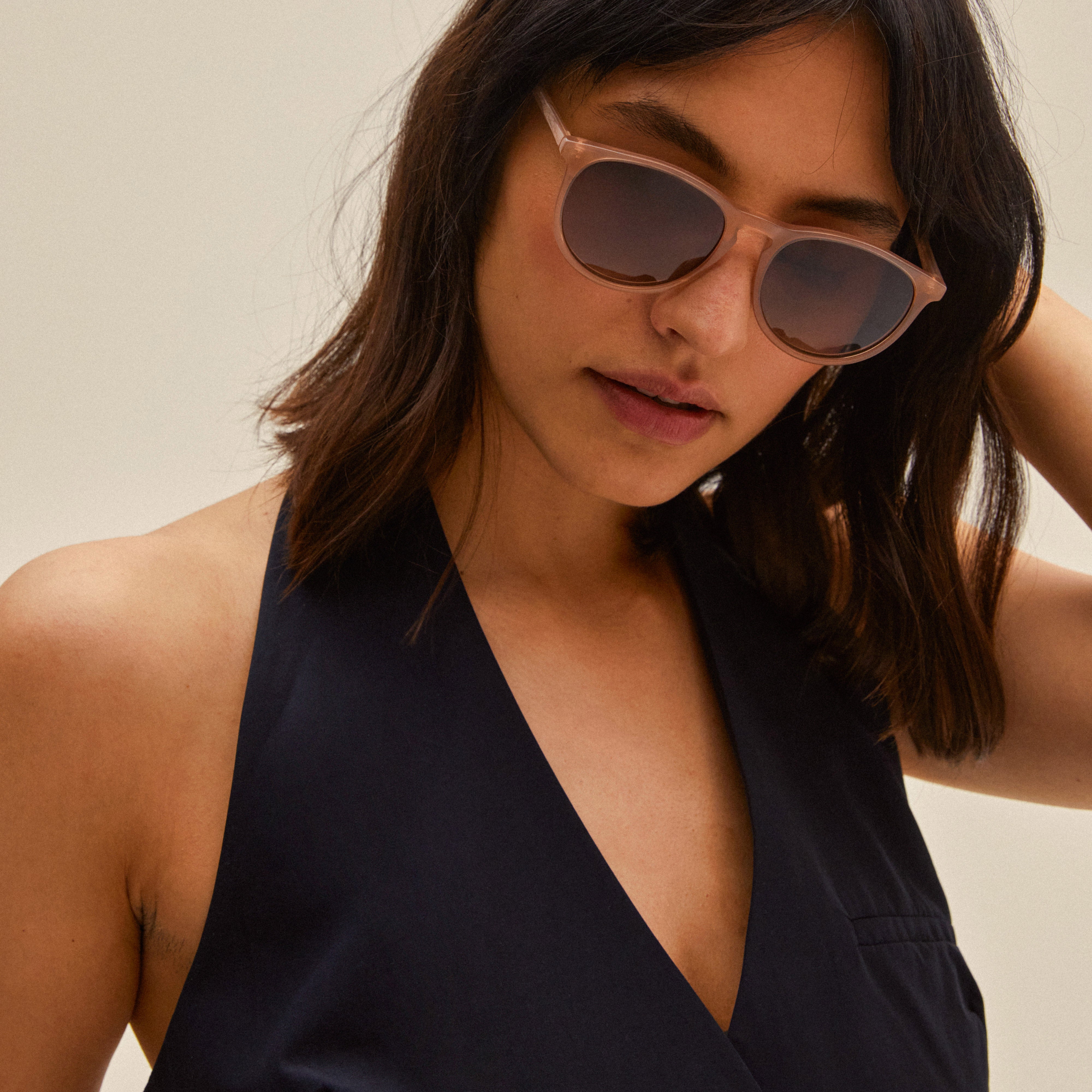 SAHARA sunglasses rose, shown on a woman, feature sleek recycled acetate frames, offering a chic look with UV400 protection, perfect for any occasion.