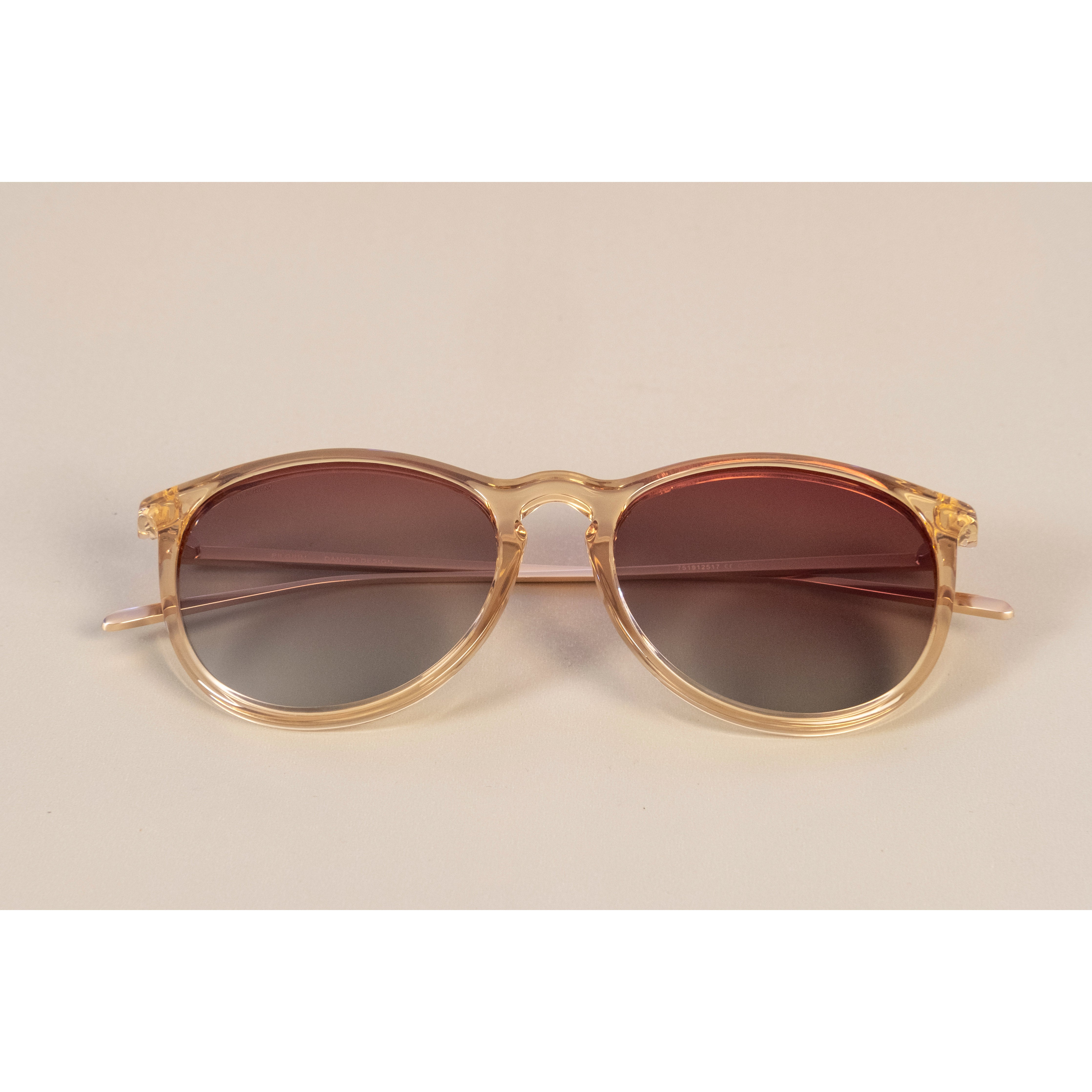 VANILLE sunglasses with slender metal temples and soft round lenses on a white surface, embodying Pilgrim's blend of timeless and trendy style.