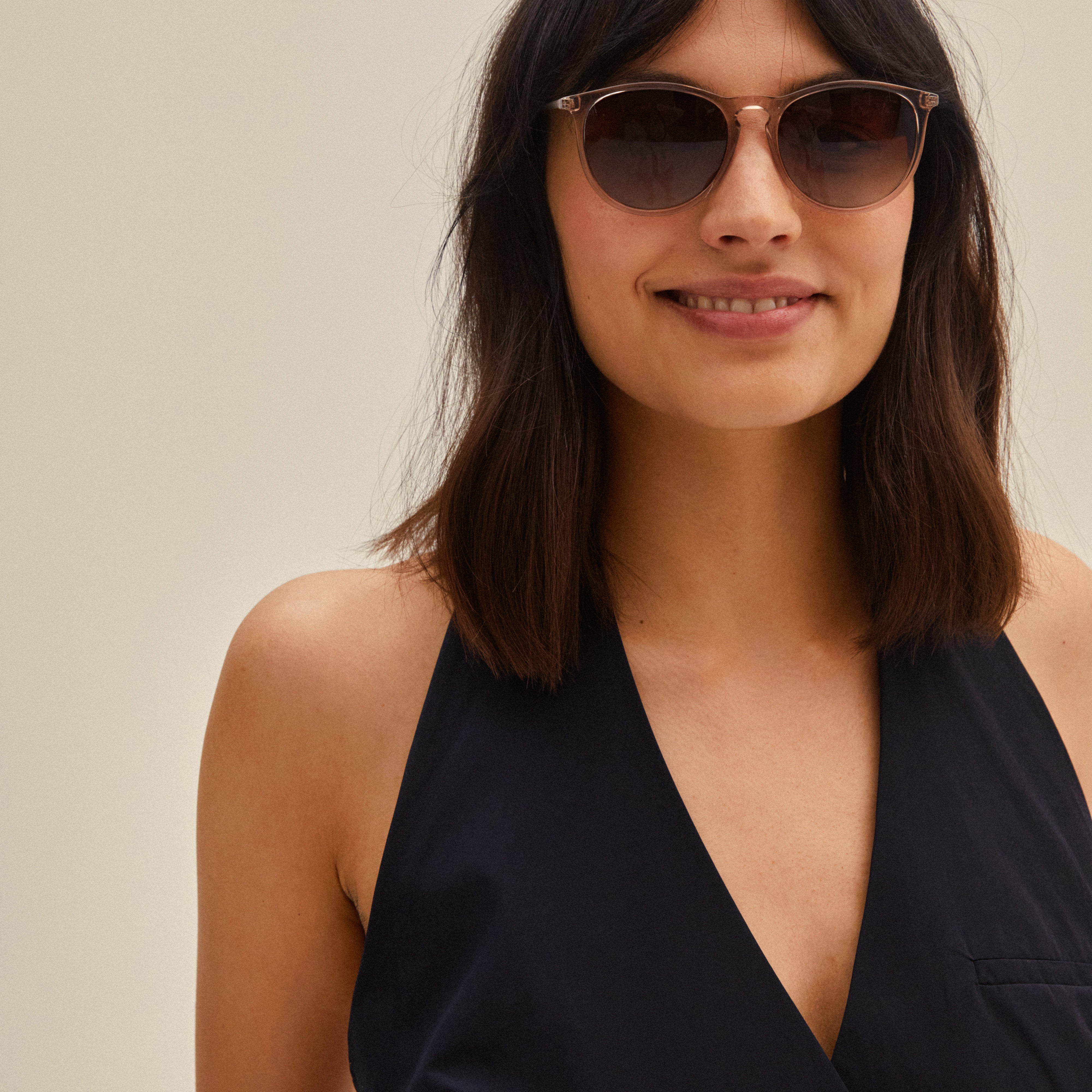 VANILLE sunglasses light brown/gold on a smiling woman, showcasing stylish slender metal temples and soft round lenses, perfect for a trendy summer look.