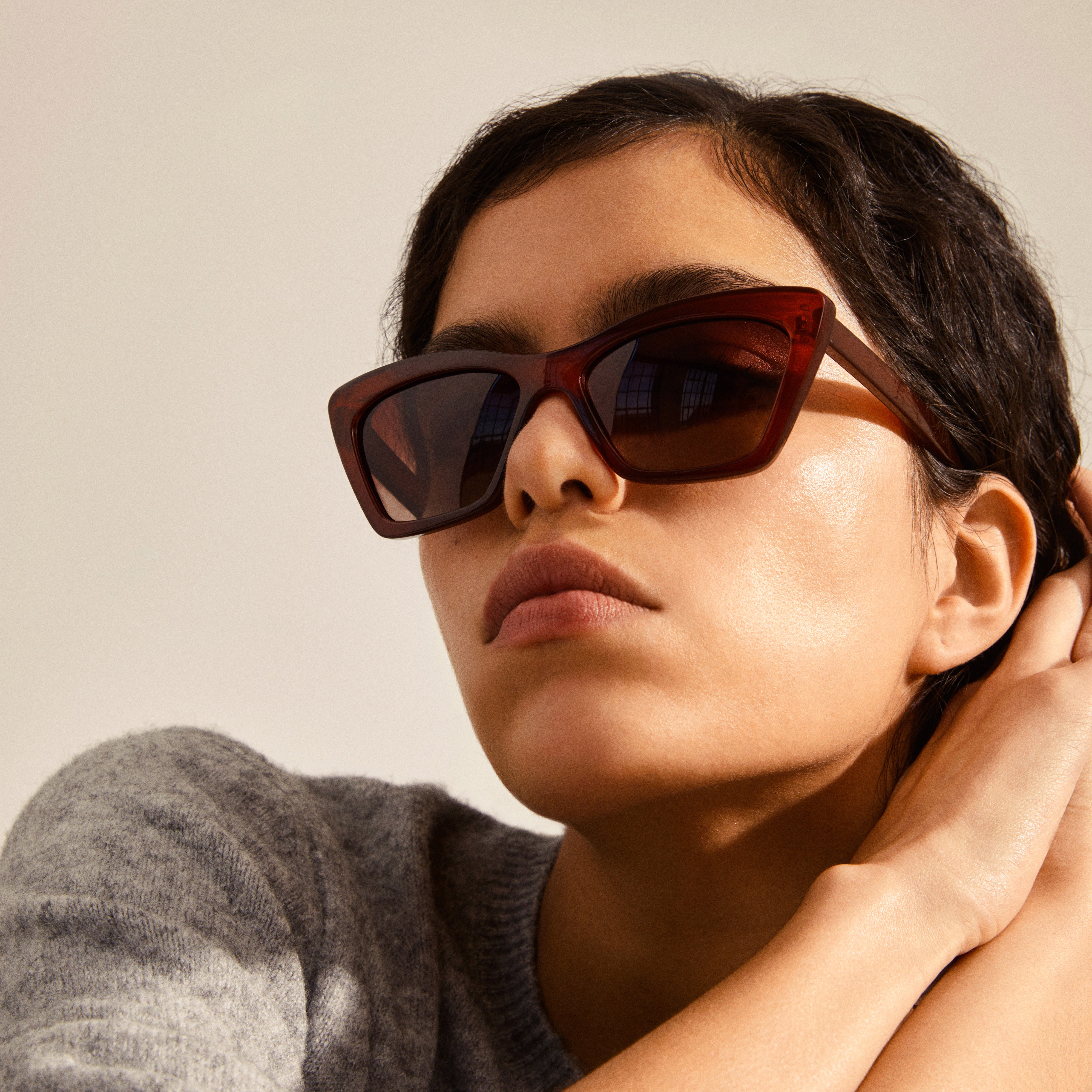 A woman wearing DAKOTA angular cat-eye shaped sunglasses from Pilgrim, highlighting her cheekbones with a stylish, feminine, and glam design.