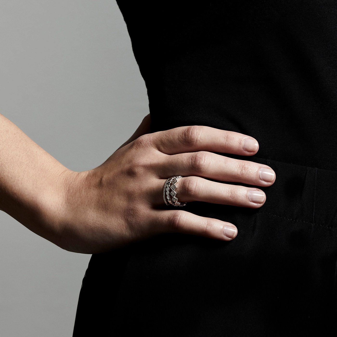 Close-up of a hand wearing the JOY silver-plated ring, showcasing its slender, detailed design suitable for a boho-inspired, stacked look.