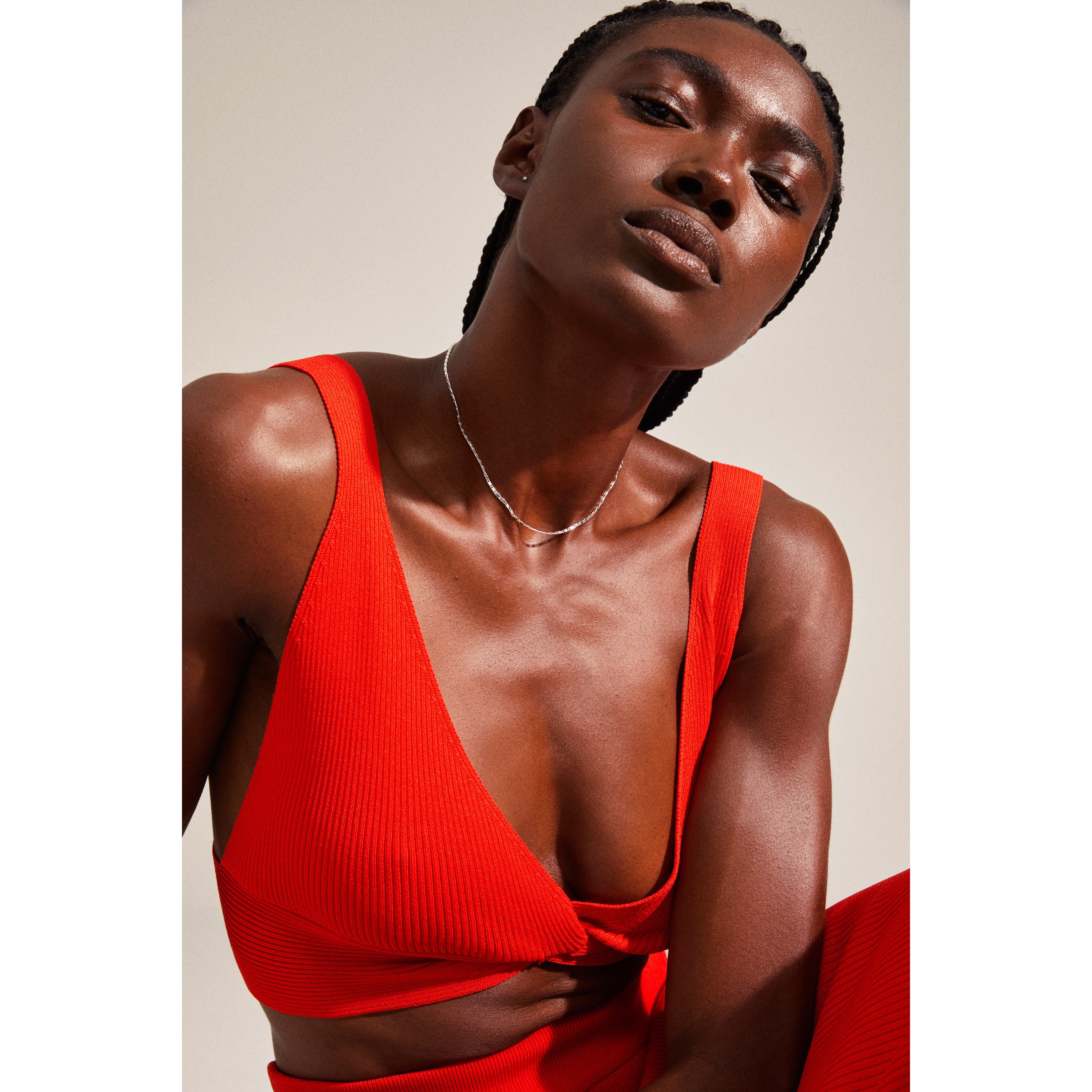 FELICIA giftset: A minimalist portrait showcasing a silver-plated flat link chain necklace with Preciosa Crystals, worn by a woman in a red ribbed crop top.