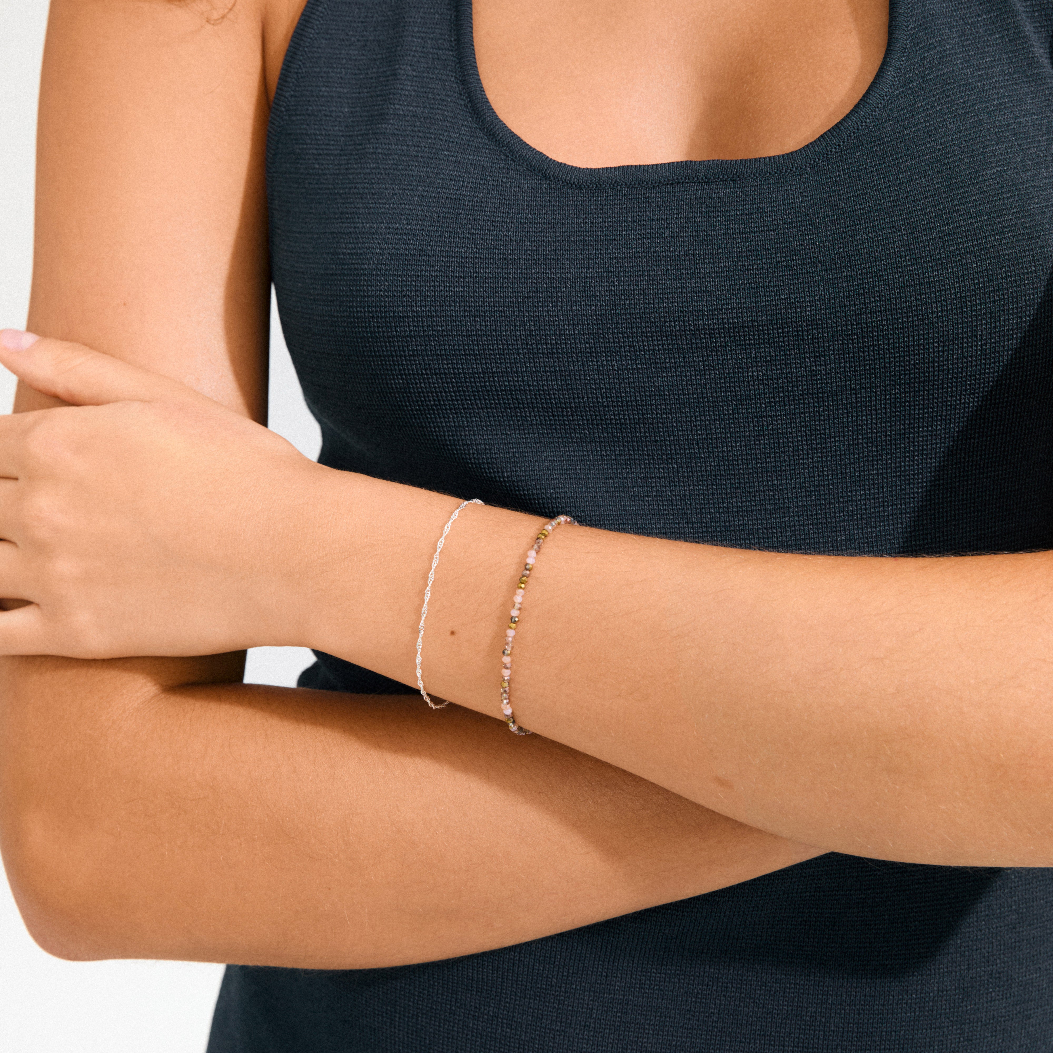 Person wearing the BELLAMY gift set: a silver-plated twisted chain and a pearl bracelet with pink and gold beads, embodying Pilgrim's timeless, trendy style.