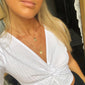 VALKYRIA coin necklace set: a woman wearing gold-plated necklaces with serpent and raven charms, showcasing Norse-inspired design against a white shirt.