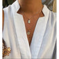 Person wearing a white shirt showcasing the VALKYRIA coin necklace 2-in-1 gold-plated set, featuring serpent and raven motifs inspired by Norse mythology.