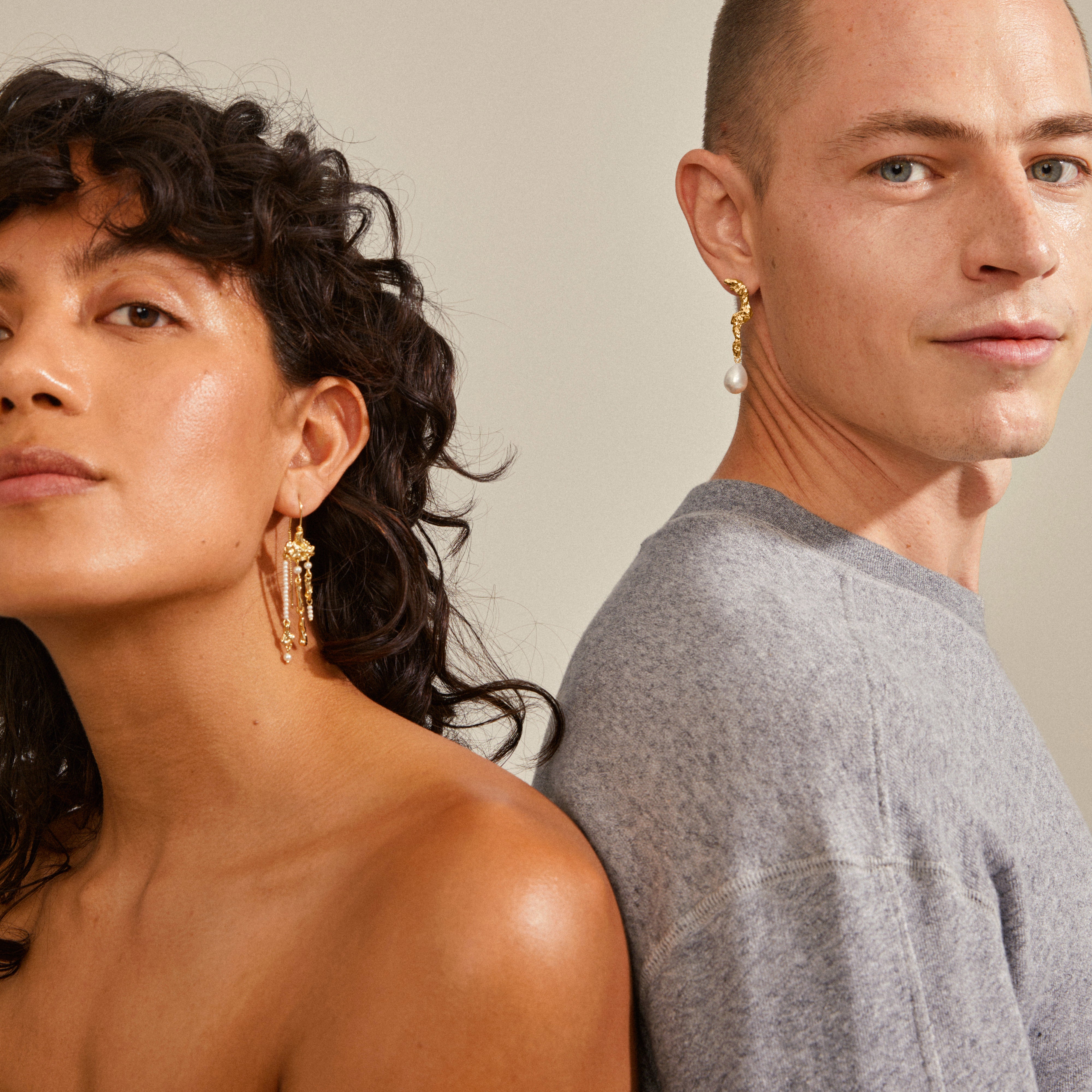 MOON earrings gold-plated, featuring asymmetrical design with gold and freshwater pearl pendants, worn by a woman with curly hair.