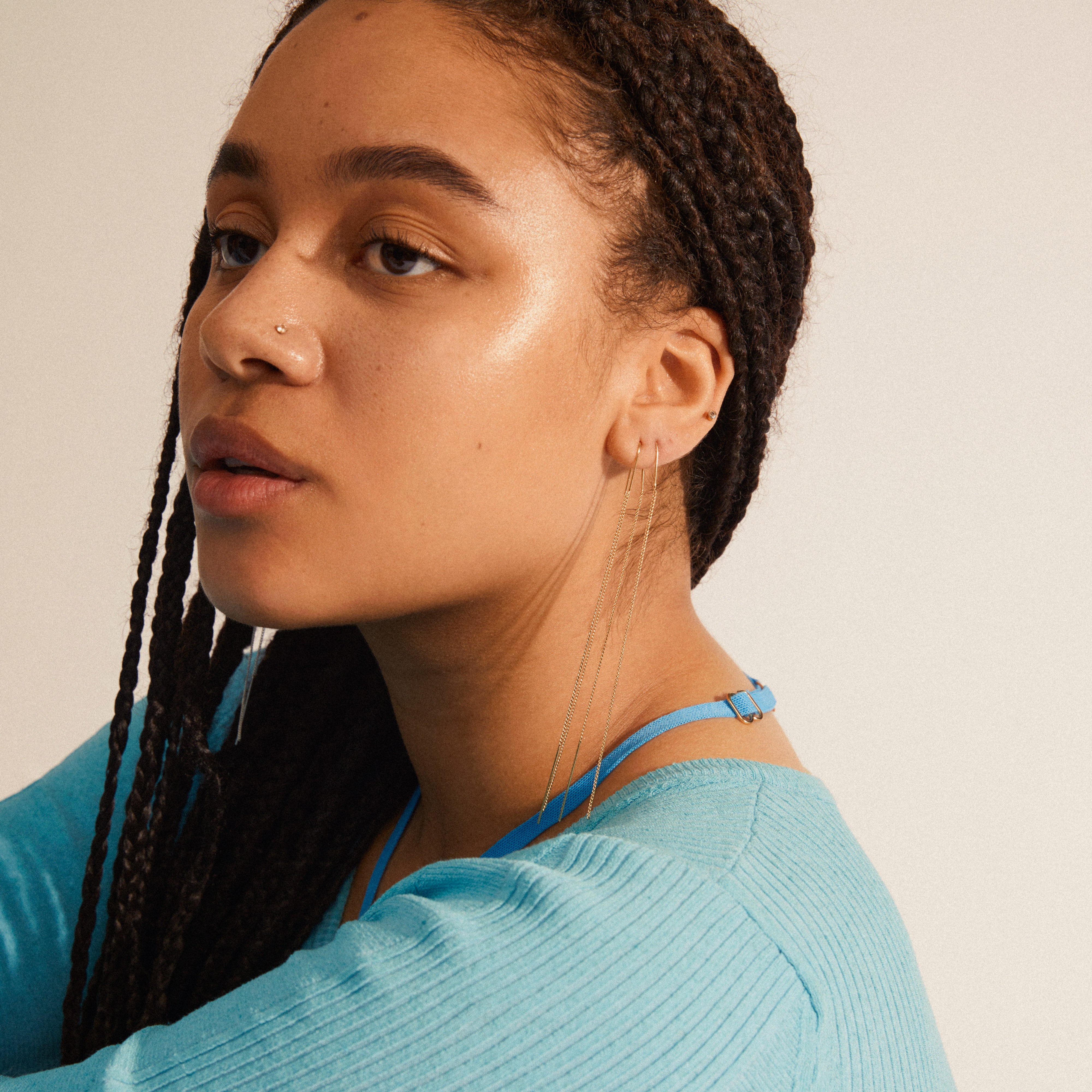 Woman with braids wearing Pilgrim's ENCHANTMENT gold-plated chain earrings, showcasing a stylish and timeless design perfect for any occasion.