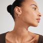 Close-up of a woman wearing Pilgrim's STAR hoops, gold-plated, with Preciosa crystals, showcasing their elegant oval shape and stylish, timeless design.