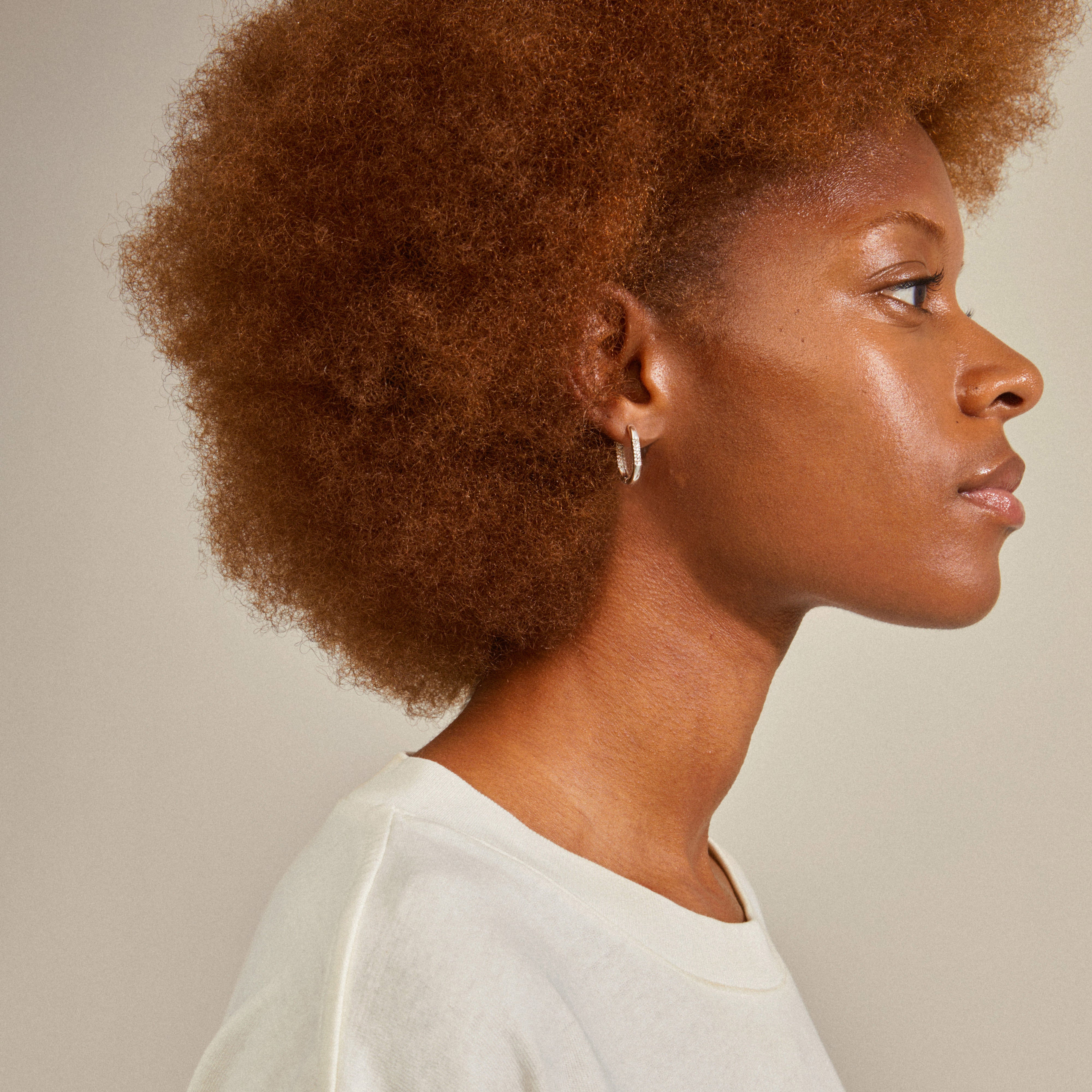 A woman wearing Pilgrim's STAR hoops, silver-plated earrings with sparkling Preciosa crystals, showcasing their elegant and luxurious design.