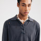 Man wearing Pilgrim's LIGHT seashell necklace, featuring irregular mother-of-pearl pieces, silver-plated chain, and semi-precious stones, exuding boho luxe vibes.