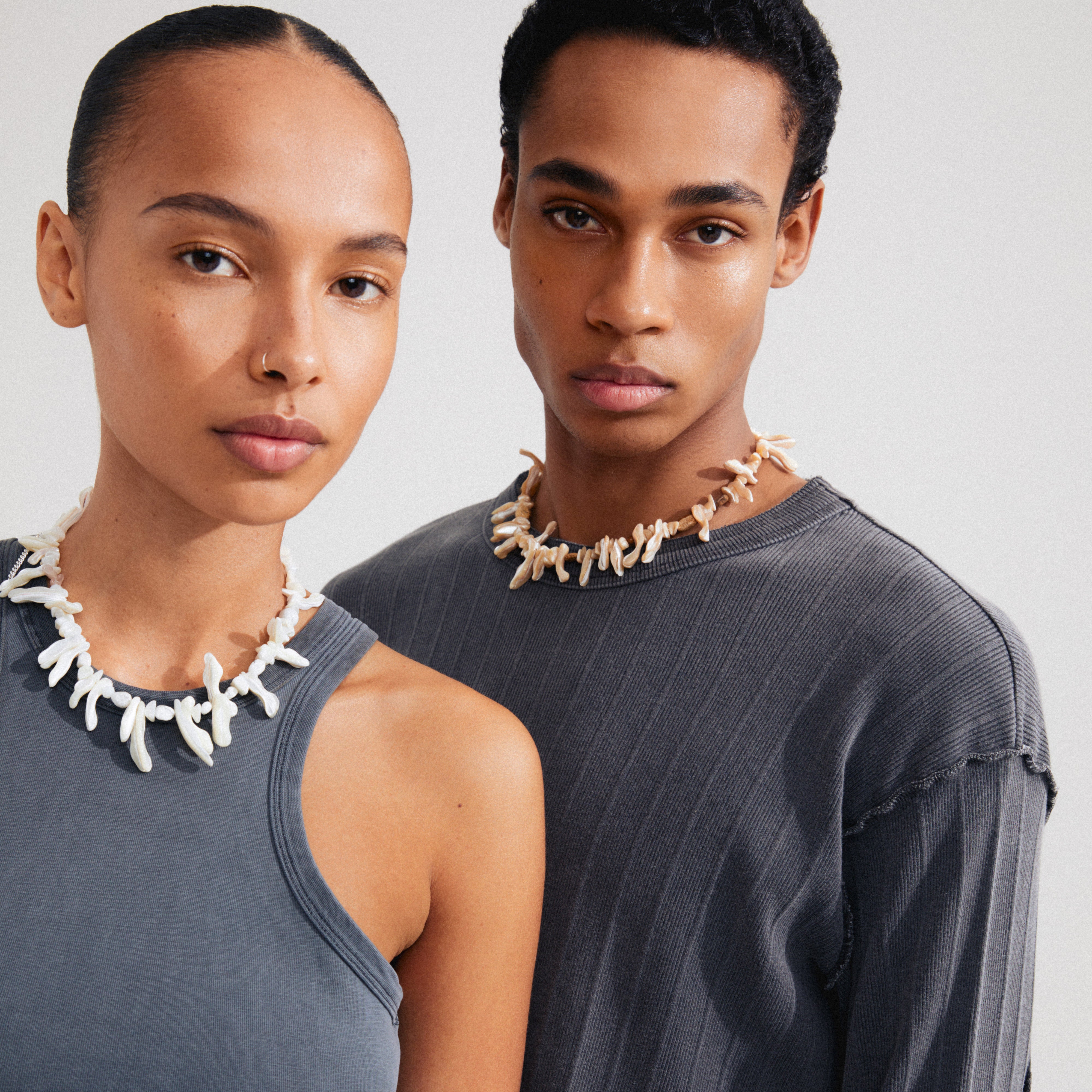 LIGHT seashell necklace white/silver-plated featuring irregular mother-of-pearl pieces and semi-precious stones, worn by a woman, highlighting beachy summer vibes and boho luxe style.