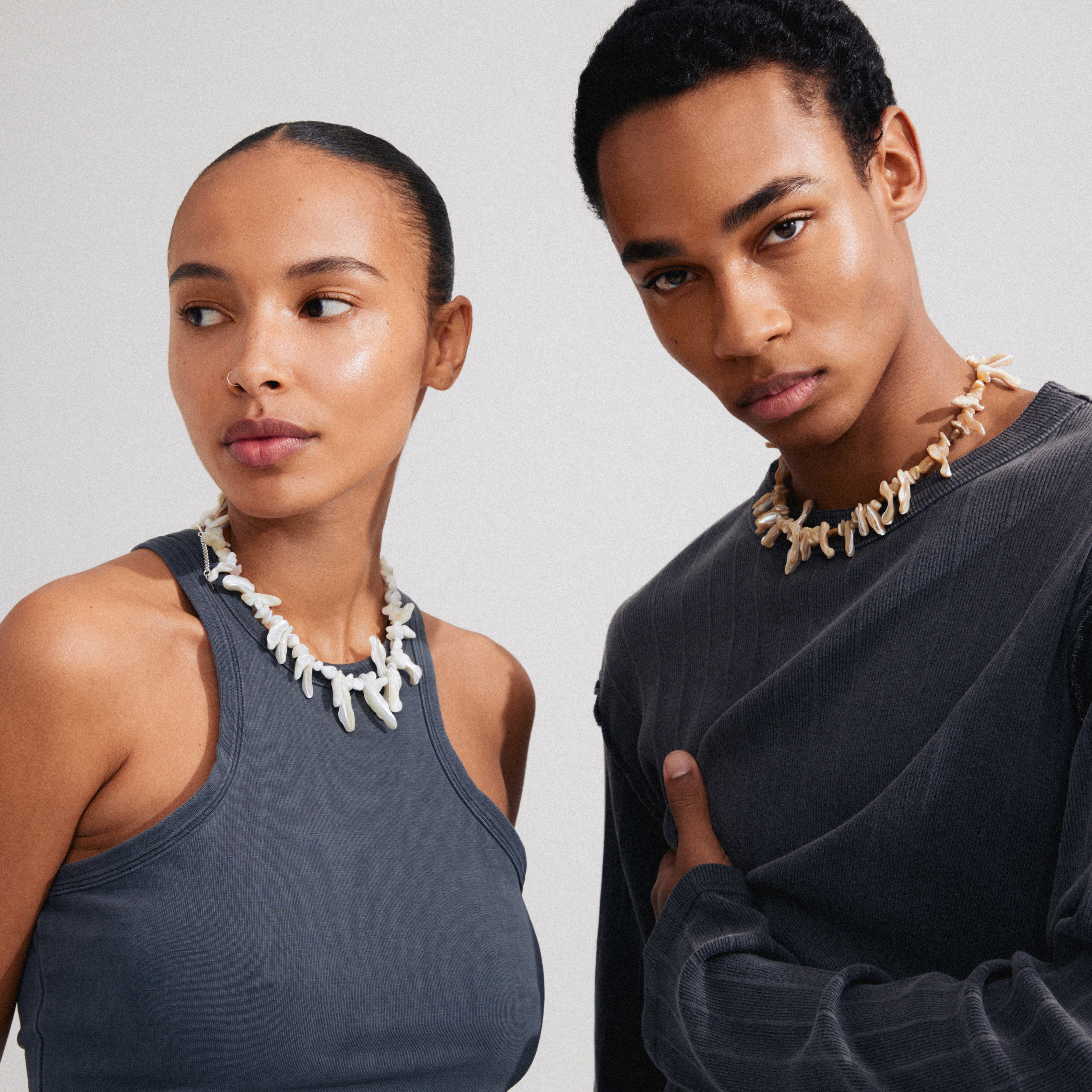 LIGHT seashell necklace white/silver-plated on a man and woman. Features irregular mother-of-pearl pieces, Rose Quartz, and White Turquoise, exuding a boho luxe vibe.