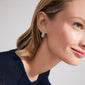 Close-up of a woman wearing Pilgrim's FOCUS crystal earrings, gold-plated with sparkling Preciosa crystals, showcasing a sleek, chunky design.