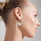 FOCUS hoop earrings silver-plated, featuring an organically formed design with genuine freshwater pearls, shown worn on a woman's ear. Perfect for a luxurious boho style.