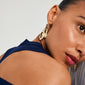Gold-plated STARLIGHT earrings on a woman, featuring chunky hoops with organic pendants, offering a statement look. Perfect for enhancing outfits with trendy elegance.
