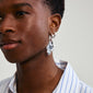 STARLIGHT earrings, silver-plated chunky hoops with organic pendants, shown on an ear. Designed for a bold statement look, crafted from recycled materials.