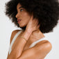 Young woman wearing Pilgrim's INSTANT bracelet, featuring flat, gold-plated rectangular links with an irregular texture, highlighting its raw, luxurious appeal.