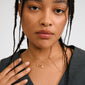 Close-up of a woman wearing the gold-plated INSTANT necklace set from Pilgrim, featuring delicate chains and a sparkling safety-pin-style pendant.