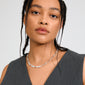 Young woman wearing Pilgrim's INSTANT necklace, silver-plated with flat, textured links, styled with her braids, showcasing a contemporary, handcrafted look.
