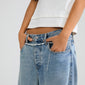 INSTANT body jewellery silver-plated chain belt with a raw, handcrafted feel, threaded through belt loops of light-wash jeans, enhancing a chic, urban look.
