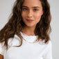 Young woman wearing Pilgrim's INSTANT silver-plated layered necklace, featuring flat, rectangular links with an irregular, handcrafted texture for an effortlessly chic, urban style.