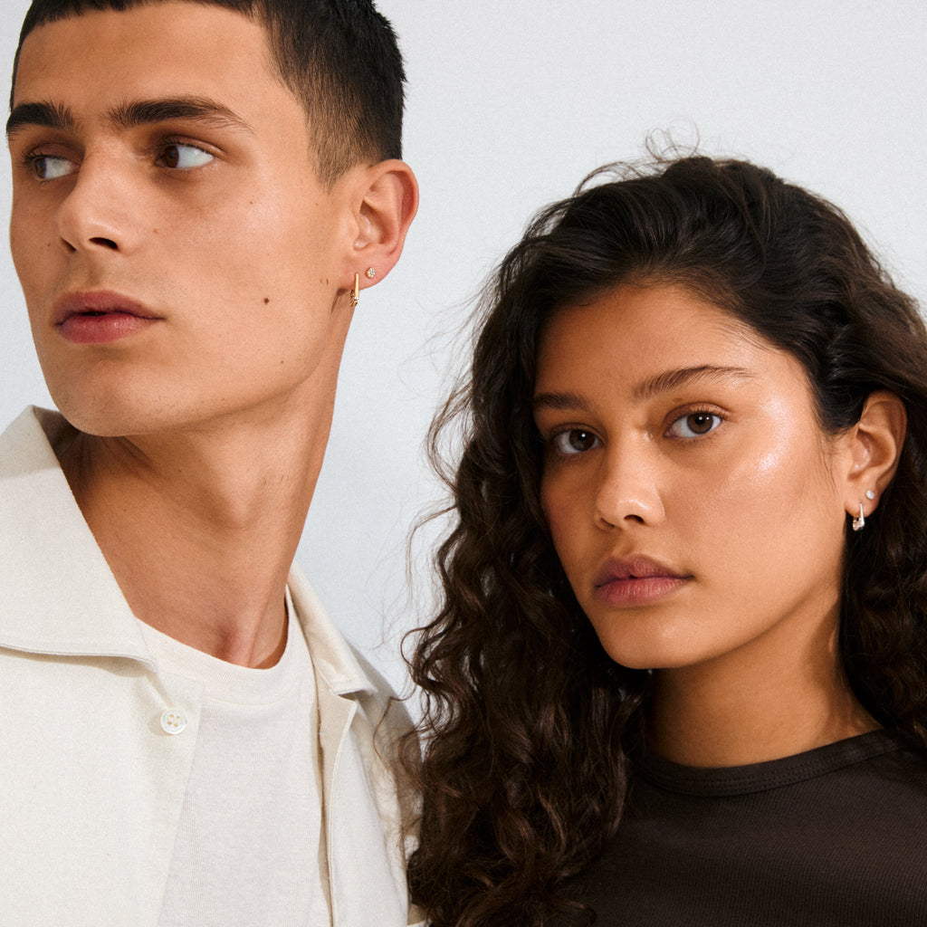 Two young people wear INSTANT earrings 2-in-1 set, silver-plated, featuring small hoop designs with Preciosa crystals, showcasing a chic, urban ear-stacking style.