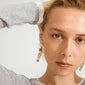 Young person wearing SPARKLE earrings gold-plated by Pilgrim, featuring dangling chain of linked circles, adding vintage flair and sparkle, perfect for chic and edgy styles.
