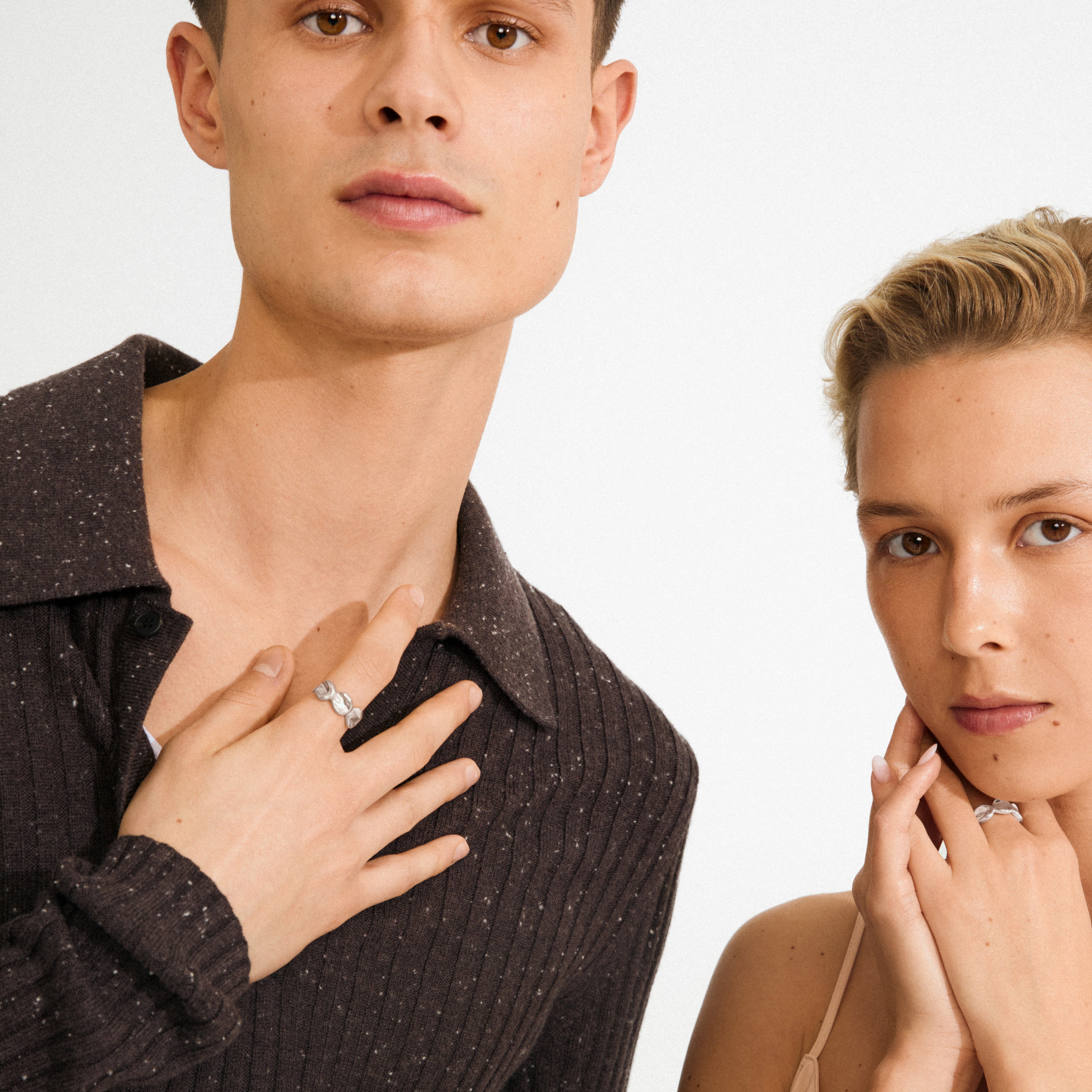 Young man and woman showcase Pilgrim's SPARKLE ring, silver-plated with a nature-inspired design, highlighting its playful light reflections and adjustable fit.