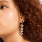 Silver-plated SPARKLE earrings, featuring polished metal segments, adorn an ear framed by curly hair, showcasing Pilgrim's handcrafted, vintage-inspired design with a chic, light-catching finish.