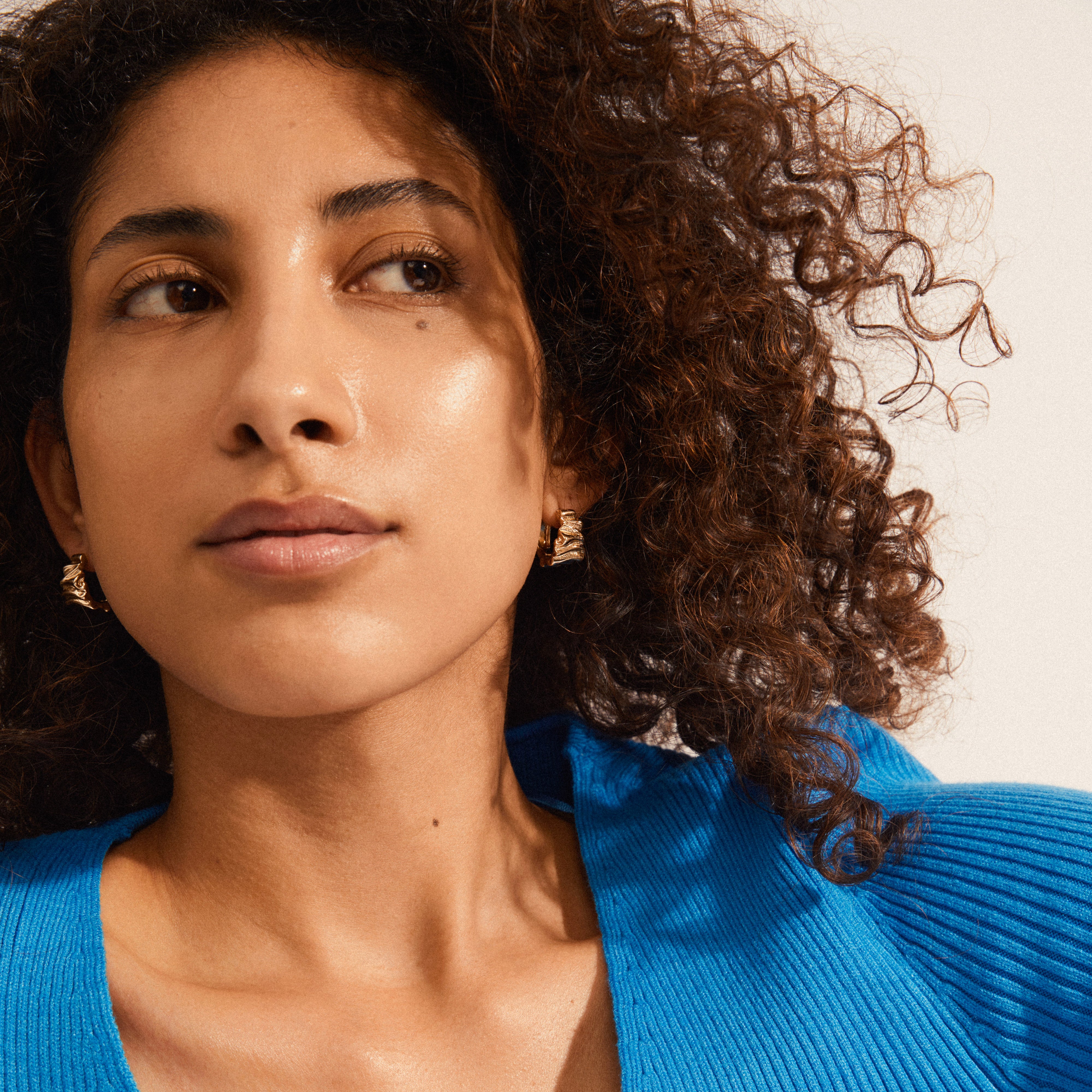 WILLPOWER huggie hoop earrings gold-plated; showcasing organic-embossed, wavy design, emphasizing Pilgrim's handcrafted Danish quality and sustainable fashion. Perfect for trendsetters seeking personal style.