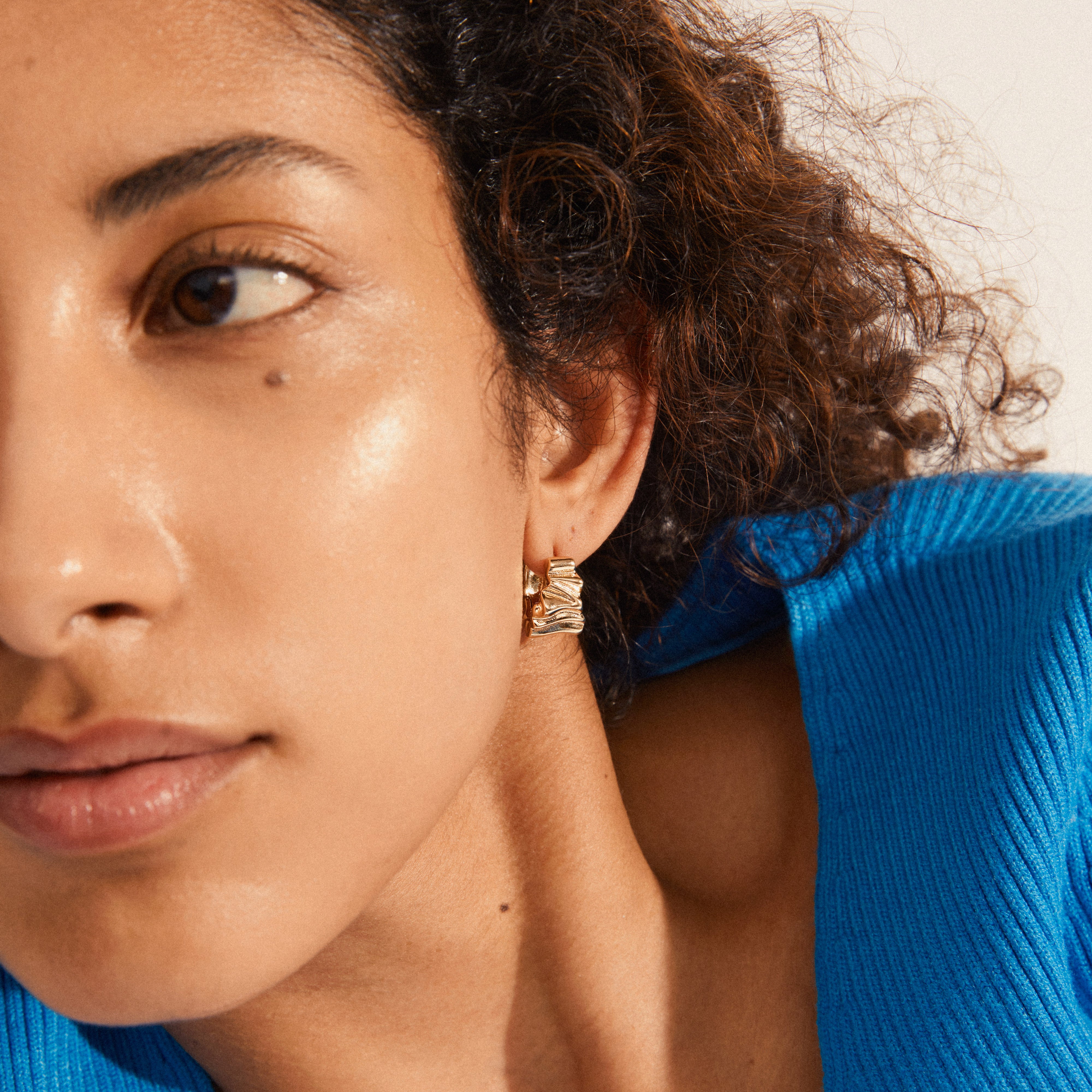 WILLPOWER huggie hoop earrings, gold-plated, featuring organic-embossed, wavy design, exemplifying Pilgrim's handcrafted Nordic style. Made from 99% recycled materials.