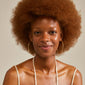 Smiling woman wearing SUN mega hoops gold-plated by Pilgrim, showcasing their large, uneven, organic design.