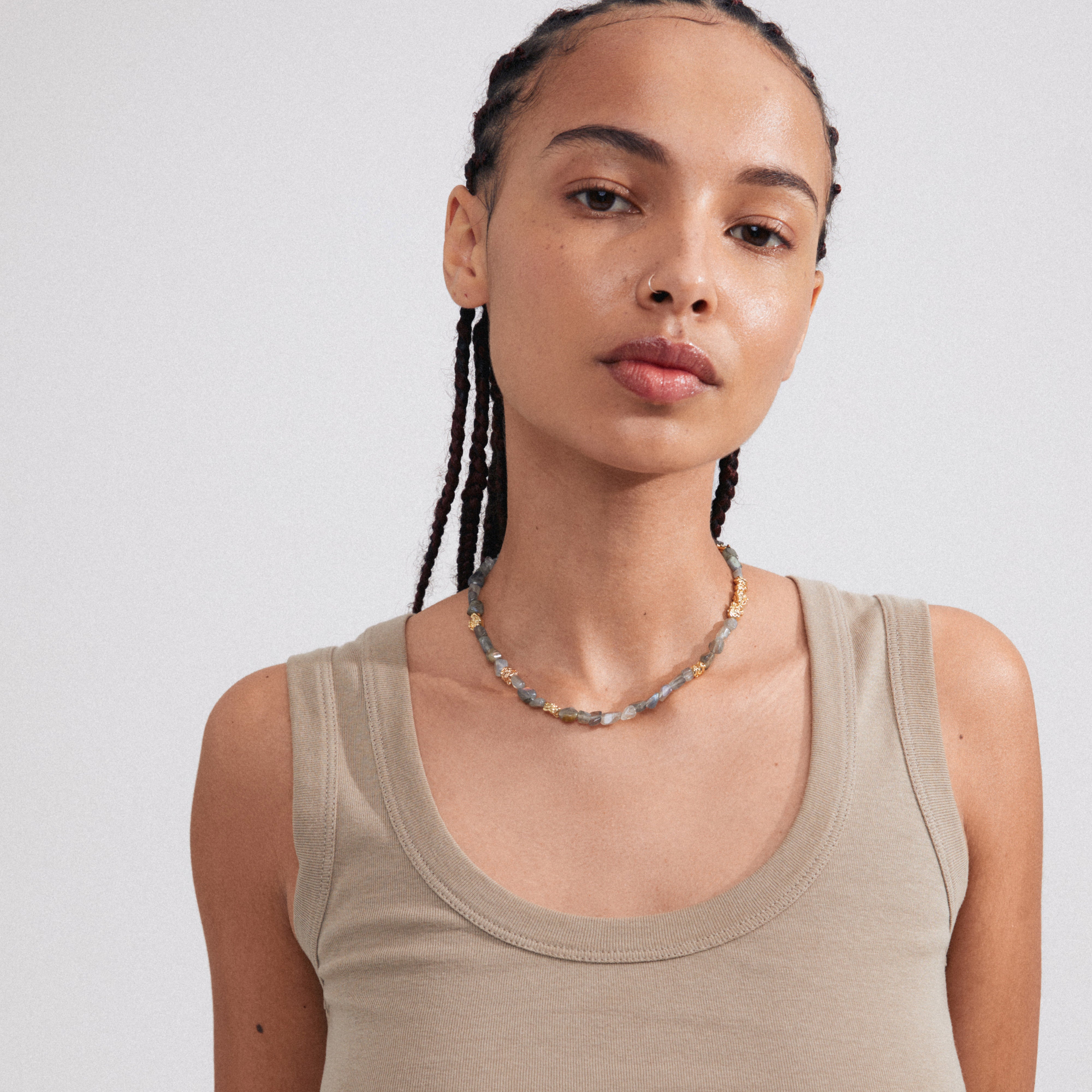 Woman wearing the TRUST necklace, gold-plated with grey Labradorite and a decorative T-bar clasp, showcasing Pilgrim's blend of timeless and trendy design.