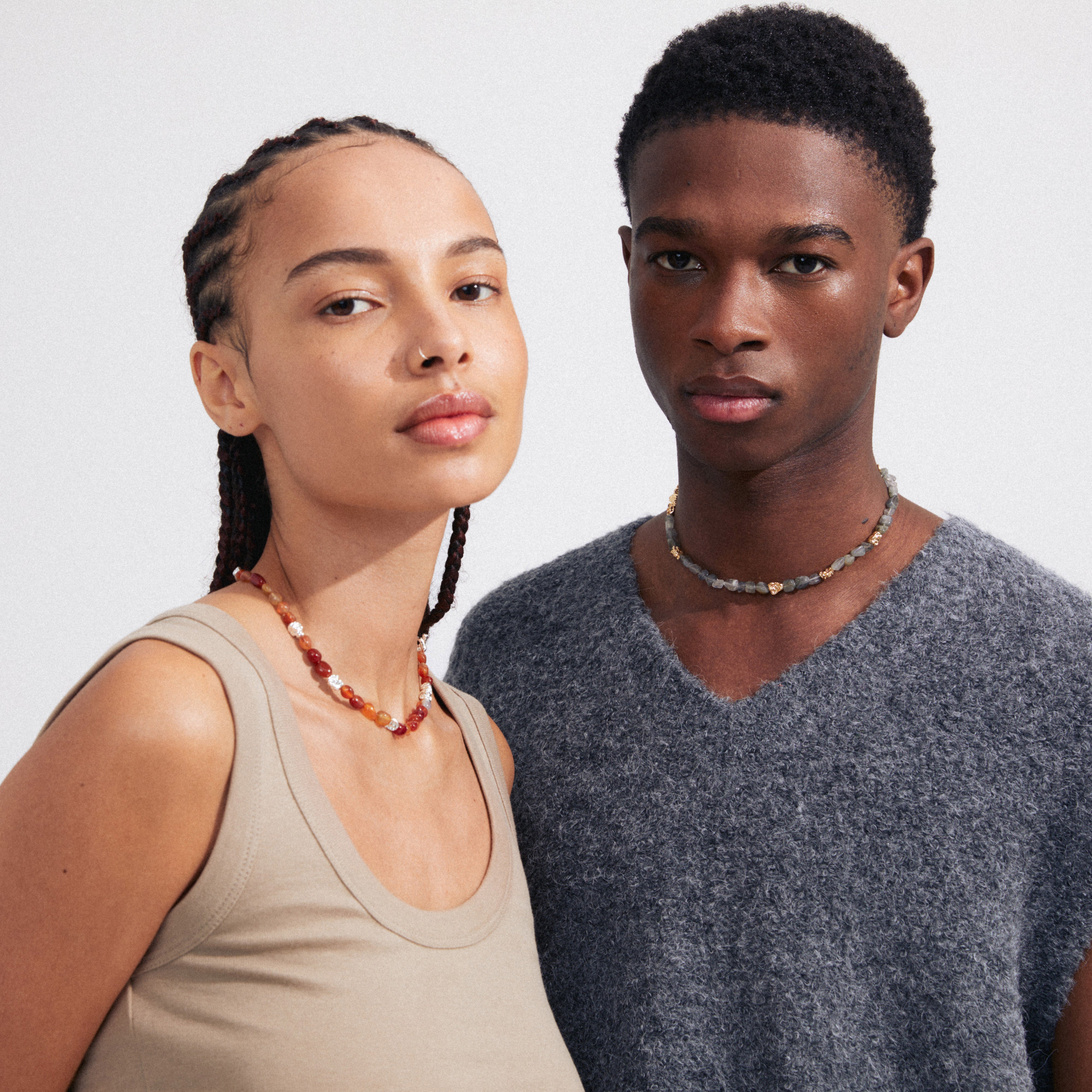 A woman wears the TRUST necklace gold-plated, featuring grey Labradorite and gold-plated details with a T-bar clasp, embodying Pilgrim's luxurious boho style.