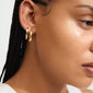 Close-up of a woman wearing Pilgrim's DAWN gold-plated earrings, showcasing their elegant, handcrafted design.