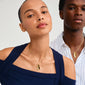 ECLIPSE necklace gold-plated, worn by a woman, features a slim curb chain with an organic leaf pendant, embodying a handcrafted, urban style.