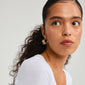 Close-up of a woman wearing Pilgrim's ECLIPSE gold-plated half hoop earrings, inspired by organic shapes, reflecting nature's beauty and artisanal design.
