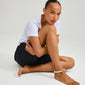 ECLIPSE ankle chain white featuring chunky ivory beads, worn by a woman sitting on the floor, exuding a relaxed beach vibe.