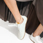 The ECLIPSE anklet features chunky, ivory beads on a neutral backdrop, worn above white sneakers, showcasing a laid-back, chic style.