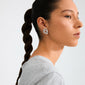 Side profile of a young woman wearing Pilgrim's UNFOLD silver-plated earrings, showcasing their intricate, artistic design and playful, indie-inspired style.
