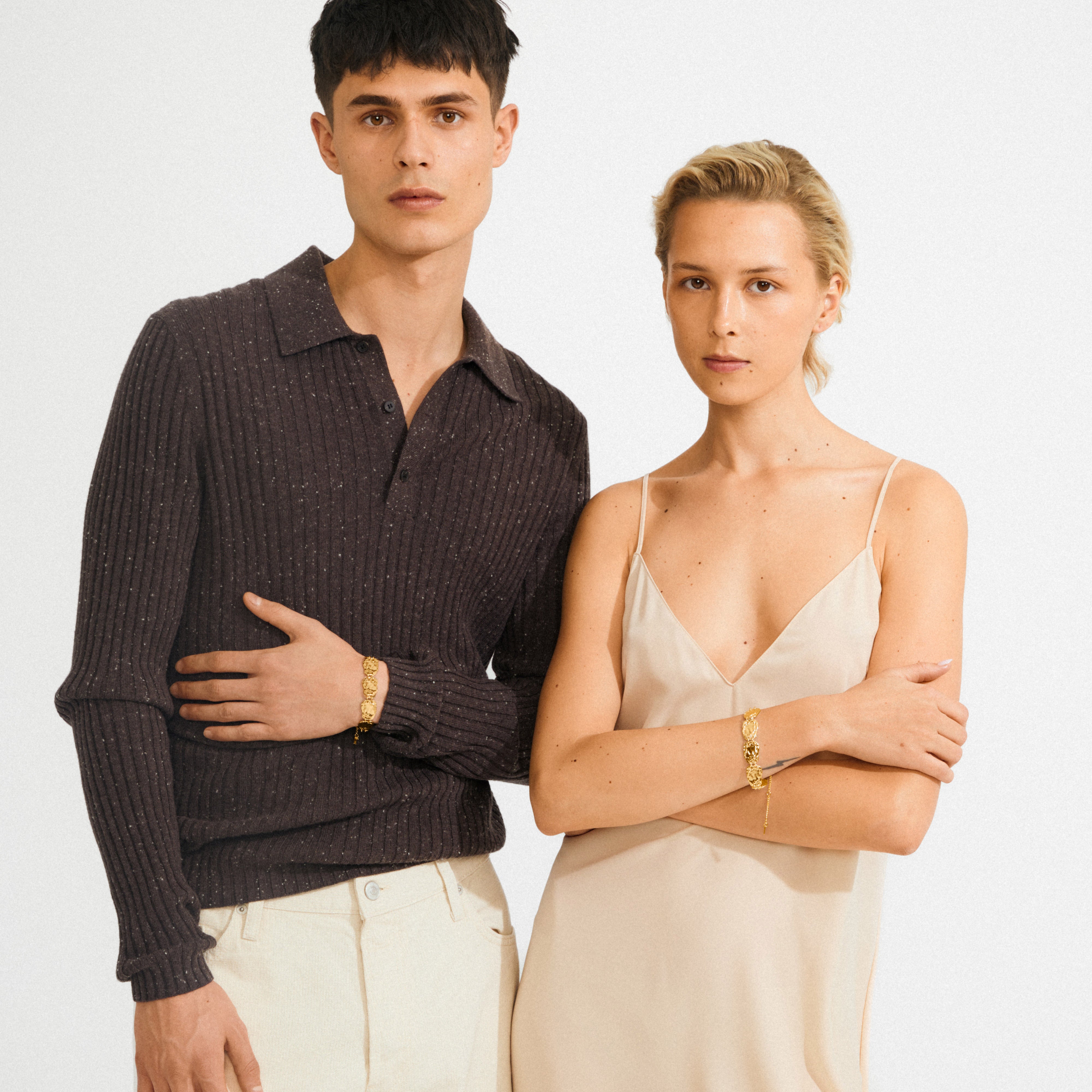 Models showcase the gold-plated SHIFT bracelet, featuring flat, wavy coins with a textured surface, highlighting its boho elegance and minimalist style.