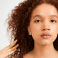 Young person wearing a sculptural gold-plated SHIFT earring by Pilgrim, showcasing a chic, handcrafted style with a focus on modern elegance.