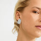 SHIFT earrings silver-plated adorn a woman's ear, featuring chunky, irregular designs with a rustic finish, embodying edgy elegance and urban coolness from Pilgrim.