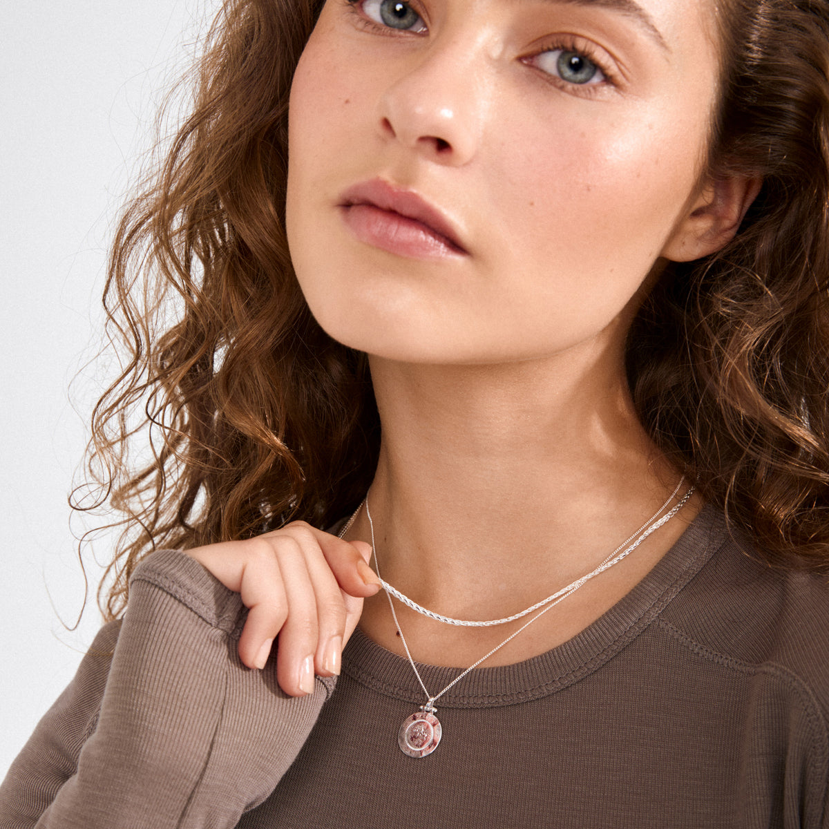Young woman wearing NOMAD 2-in-1 coin necklace silver-plated, featuring two layered delicate silver chains, one with a small round pendant, perfect for a boho-chic look.