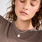 Young person with closed eyes wearing the NOMAD 2-in-1 coin necklace silver-plated, featuring layered silver chains and a coin pendant, conveying a boho yet timeless style.